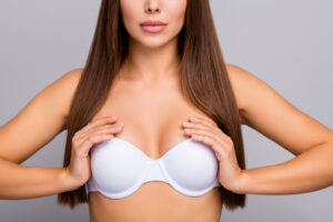 Cropped close-up portrait of her she nice-looking attractive lovely pretty healthy confident straight-haired girl wearing touching bra cancer therapy treatment isolated on gray pastel color background